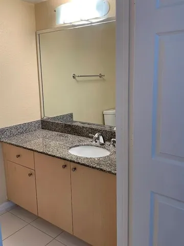 a bathroom with a granite countertop sink and vanity