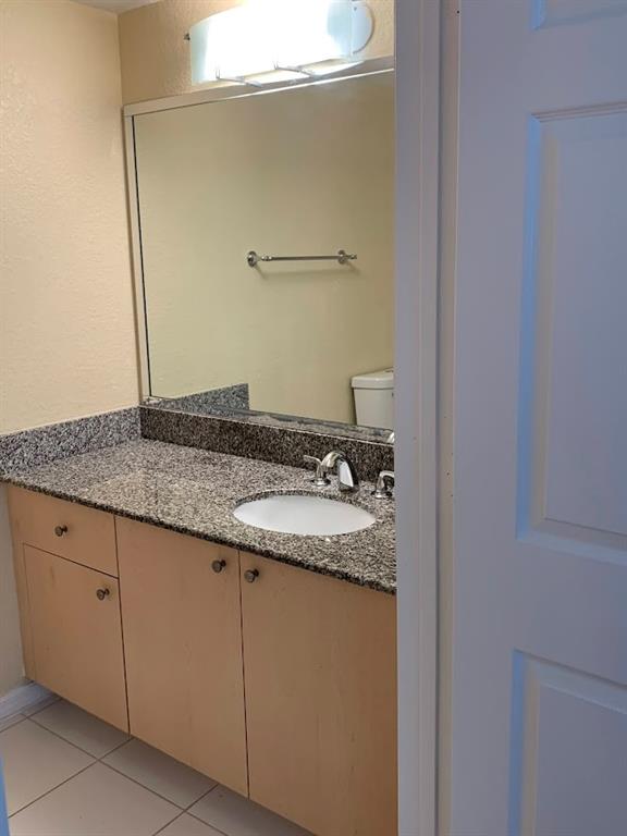 2565 Centergate Drive, Unit 204 Miramar, FL 33025 - Photo 11 of 30 a bathroom with a granite countertop sink and vanity