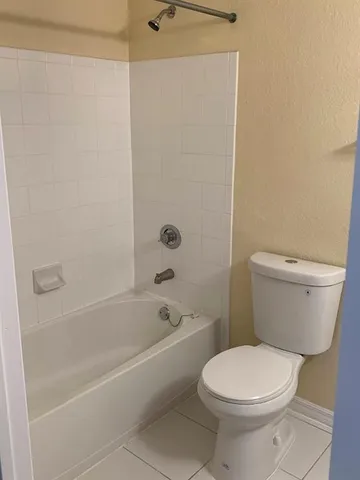 a white toilet and tub sitting next to a bathroom sink
