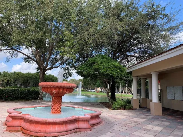 a view of a house with backyard fountain and fire pit