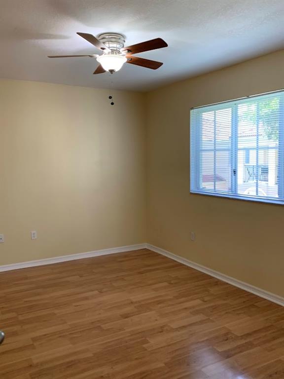 2565 Centergate Drive, Unit 204 Miramar, FL 33025 - Photo 9 of 30 a view of a room with wooden floor chandelier fan and windows