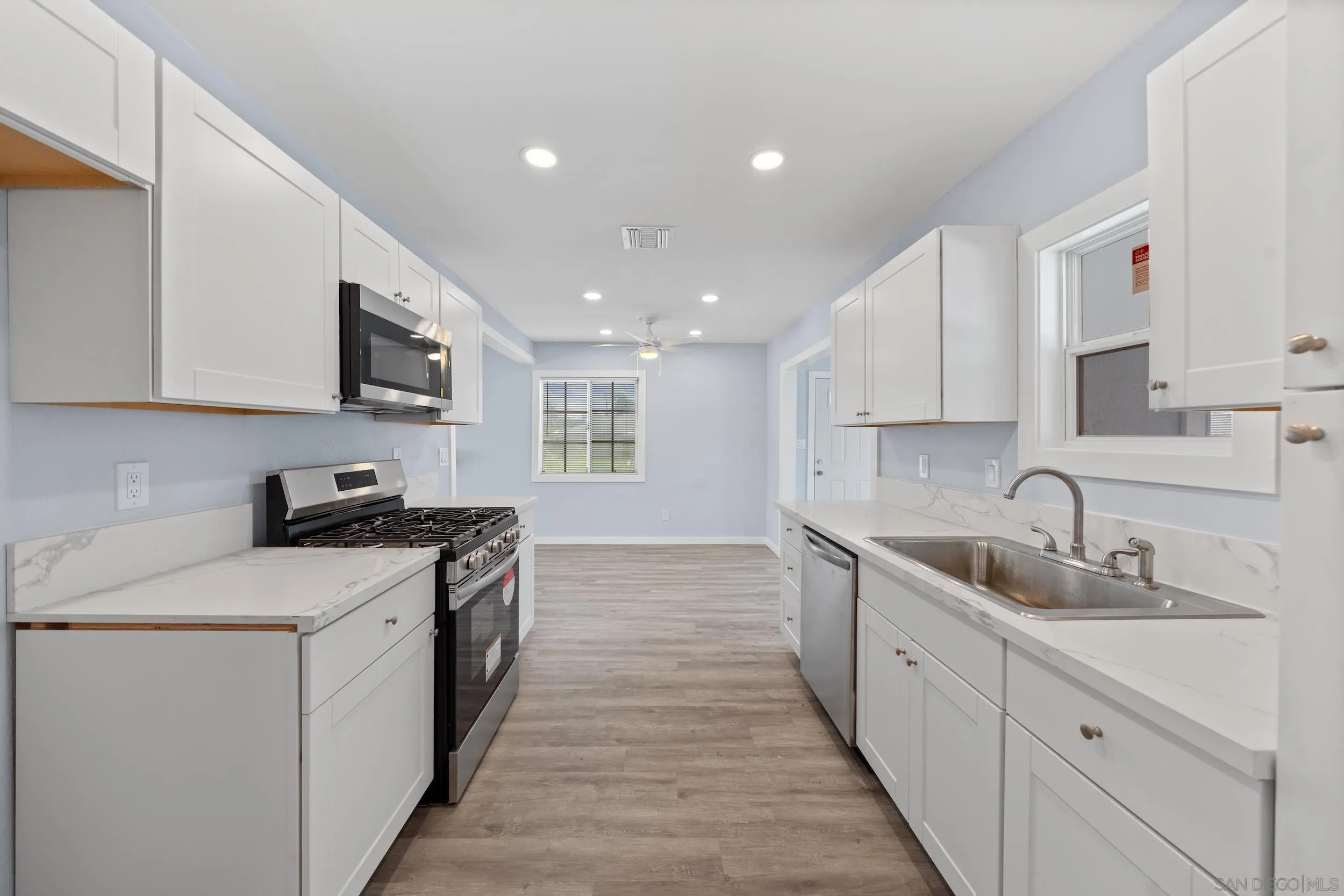3563 Cannes Avenue Riverside, CA 92501 - Photo 11 of 21 a kitchen with a sink stove and cabinets