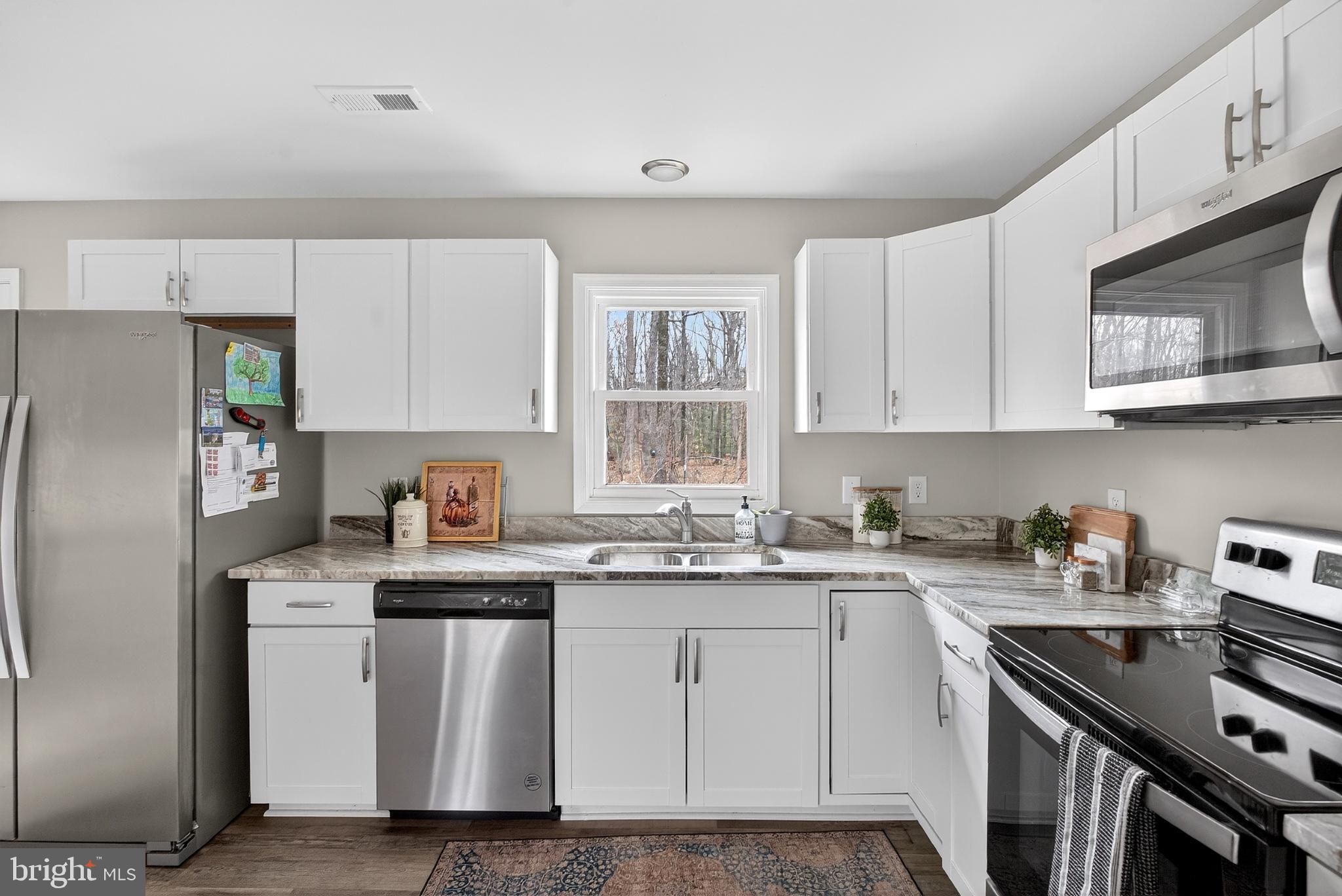 20045 Courtney Road Hanover, VA 23069 - Photo 5 of 21 a kitchen with stainless steel appliances granite countertop a sink stove refrigerator and cabinets
