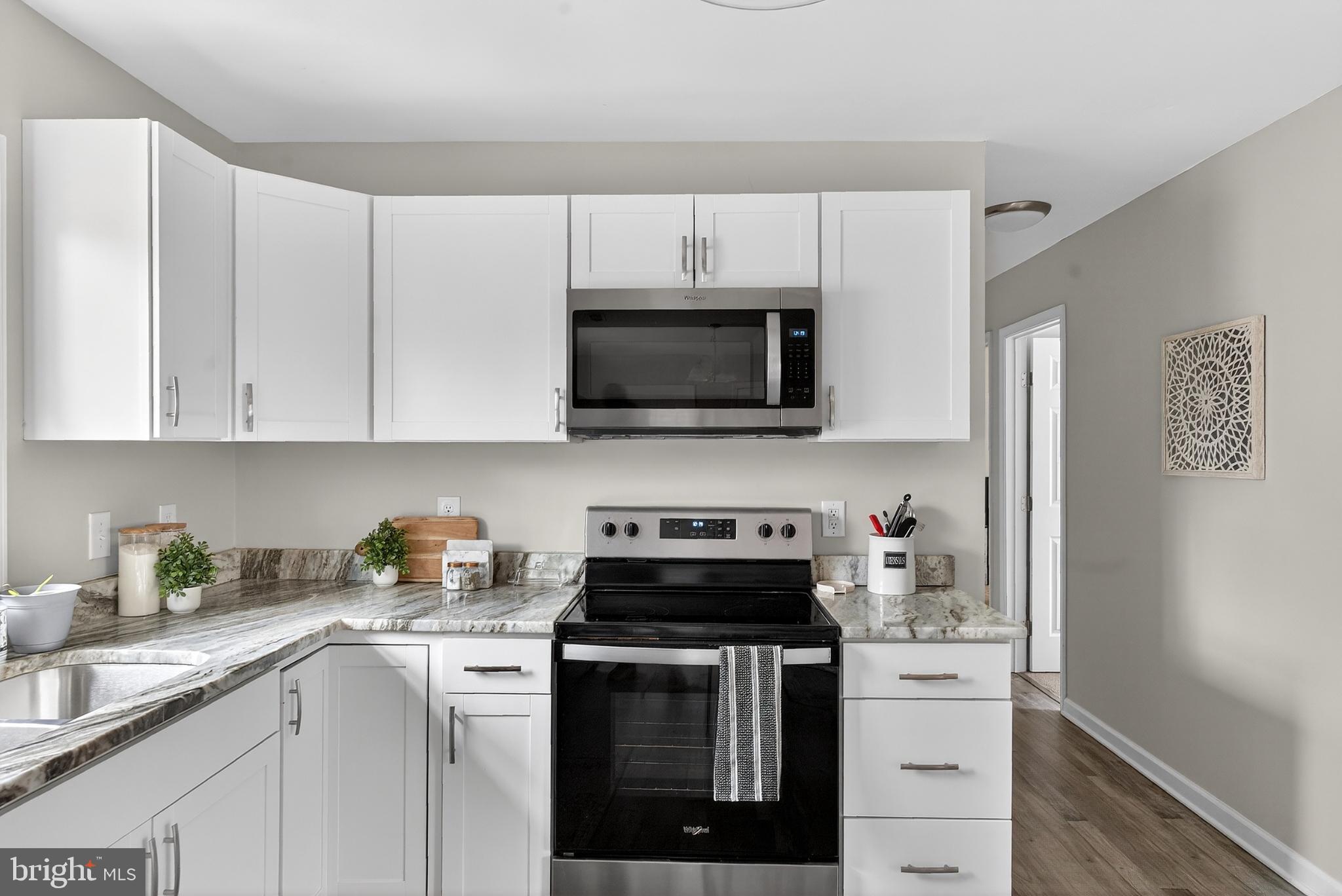 20045 Courtney Road Hanover, VA 23069 - Photo 6 of 21 a kitchen with stainless steel appliances granite countertop white cabinets a stove a microwave and a sink
