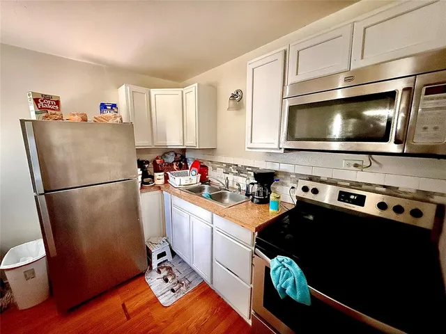a kitchen with stainless steel appliances a stove refrigerator sink and microwave