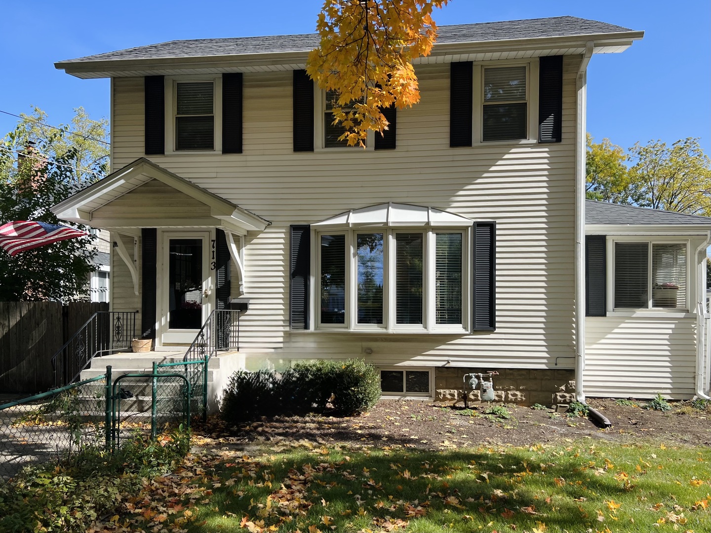 a view of a white house with large windows and flower plants