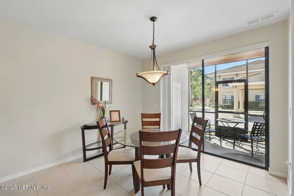 a kitchen with stainless steel appliances kitchen island granite countertop a refrigerator a stove a sink and white cabinets with wooden floor