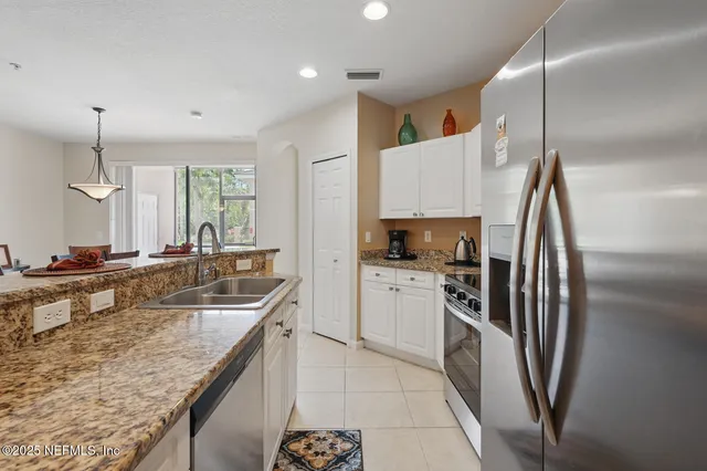 a kitchen with stainless steel appliances granite countertop a refrigerator and a stove top oven
