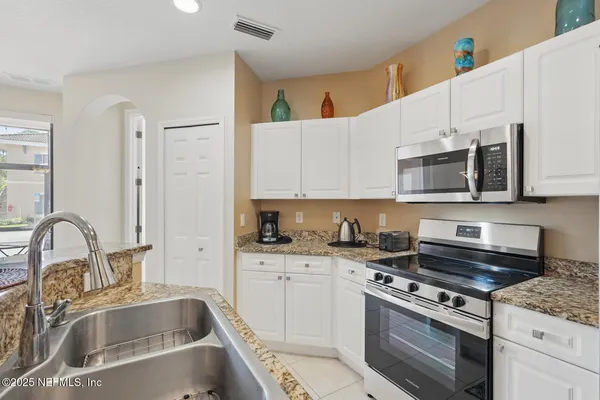 a kitchen with stainless steel appliances granite countertop a refrigerator and a stove top oven