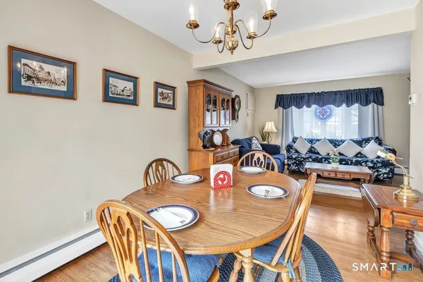 a view of a dining room with furniture a chandelier and wooden floor