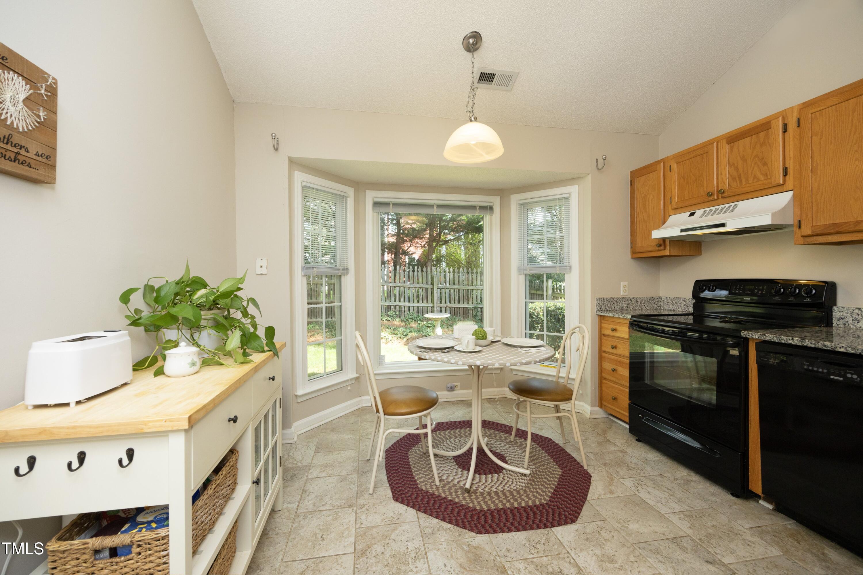 5513 Edgebury Road Raleigh, NC 27613 - Photo 10 of 34 a kitchen with a stove a sink and cabinets
