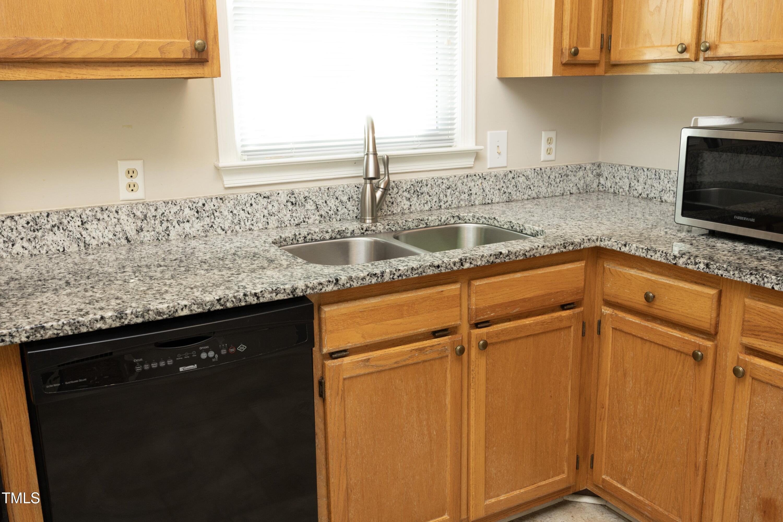 5513 Edgebury Road Raleigh, NC 27613 - Photo 14 of 34 a kitchen with granite countertop a sink stainless steel appliances and cabinets