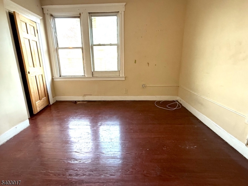 66 Scheerer Avenue Newark, NJ 07112 - Photo 14 of 24 an empty room with wooden floor and windows
