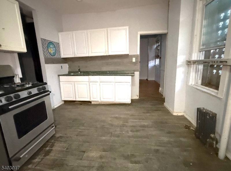 66 Scheerer Avenue Newark, NJ 07112 - Photo 7 of 24 a kitchen with granite countertop a stove a sink and a refrigerator