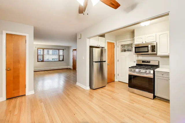 a kitchen with granite countertop a refrigerator and a stove top oven