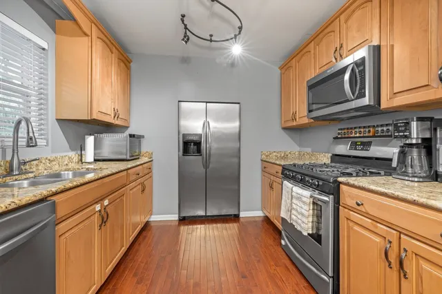 a kitchen with stainless steel appliances granite countertop a stove a sink and a refrigerator