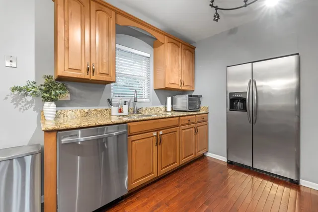 a kitchen with stainless steel appliances granite countertop a refrigerator sink and cabinets
