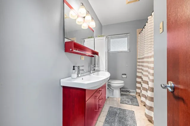 a bathroom with a sink a toilet and mirror