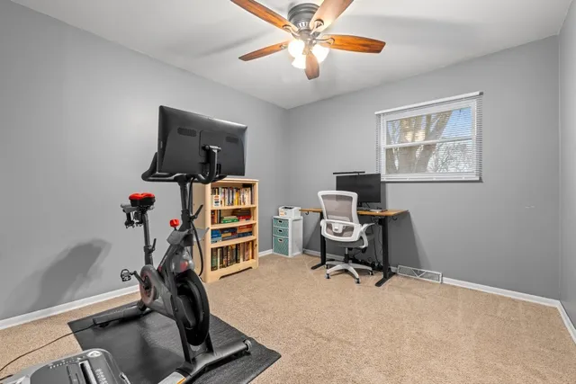 a view of a workspace with furniture and a window