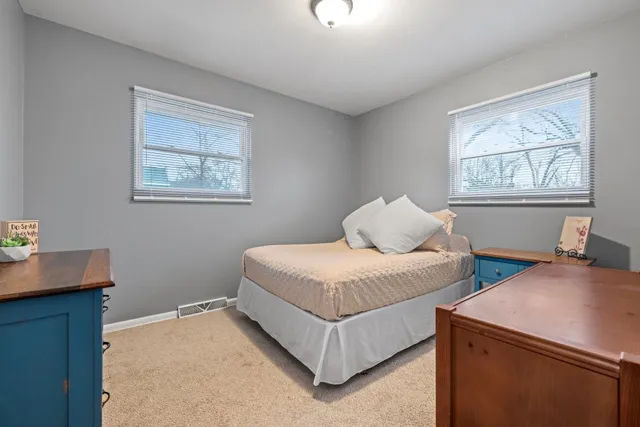 a bedroom with 2 bed and a window