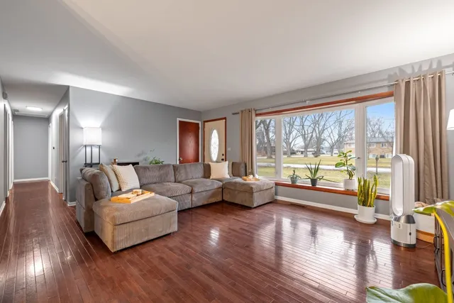 a living room with furniture and a large window with wooden floor