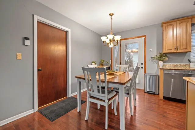 a view of a dining room with furniture a chandelier and wooden floor