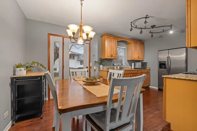 a view of a dining room with furniture a chandelier and wooden floor