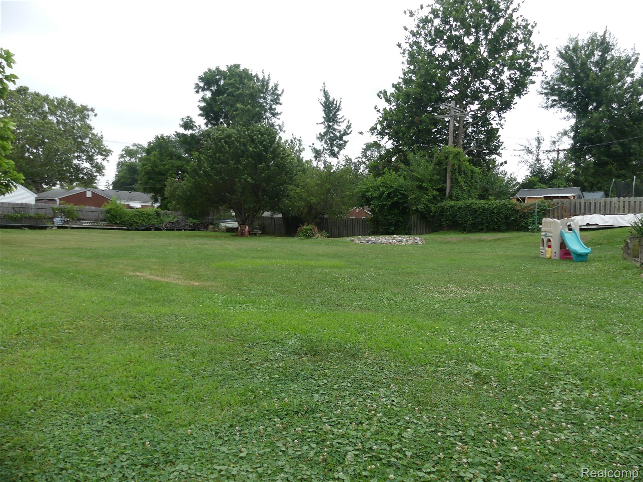 8335 Pardee Road Taylor, MI 48180 - Photo 3 of 23 Expansive grassy lawn with surrounding mature trees and partial privacy fencing