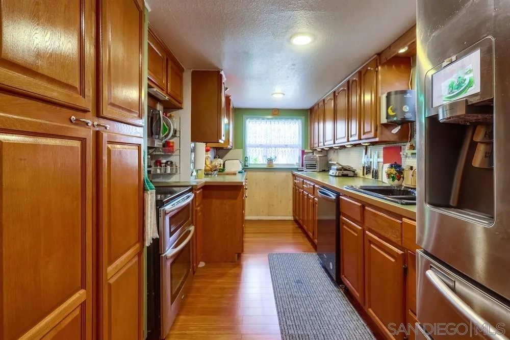 17745 Highway 67 Ramona, CA 92065 - Photo 7 of 24 a kitchen with stainless steel appliances granite countertop refrigerator a sink dishwasher a stove top oven a refrigerator and cabinets