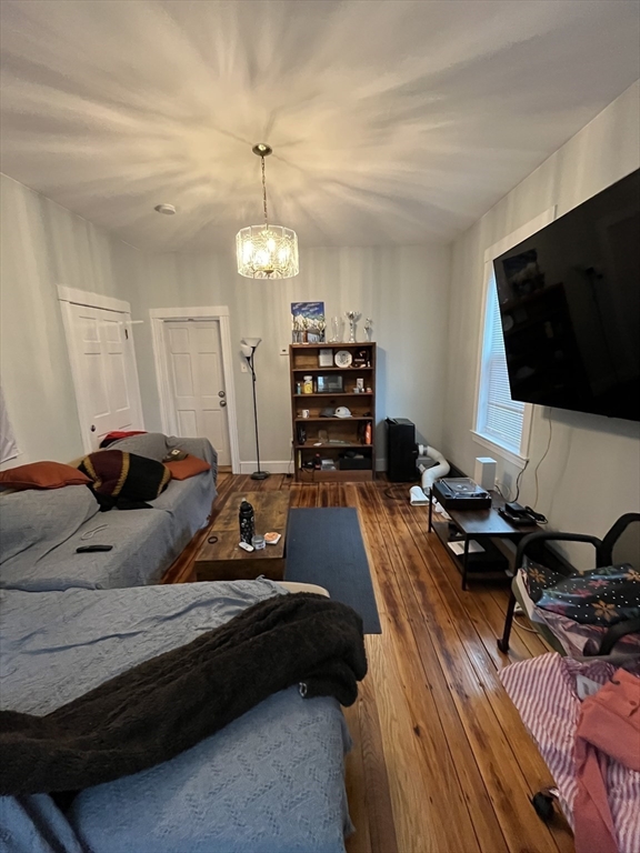 63 Marshfield Street, Unit 1 Boston, MA 02119 - Photo 5 of 26 a bedroom with a bed window and a flat screen tv