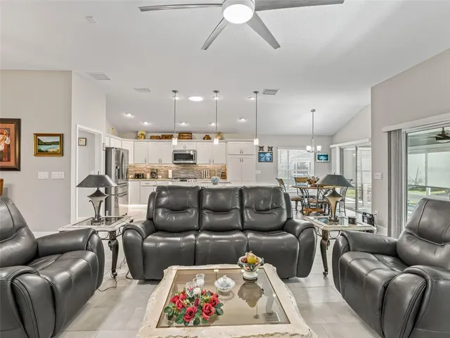 a living room with furniture kitchen view and a chandelier