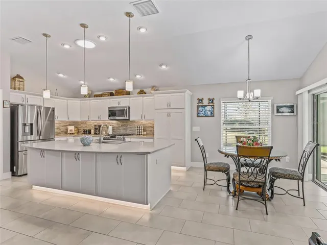 a large kitchen with a table and chairs