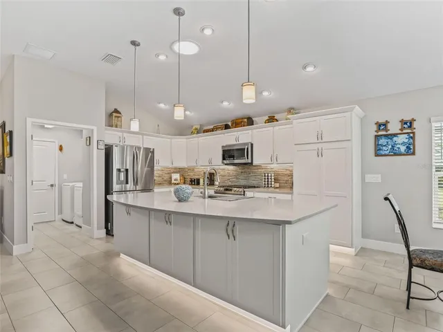 a kitchen with stainless steel appliances kitchen island granite countertop a sink and cabinets