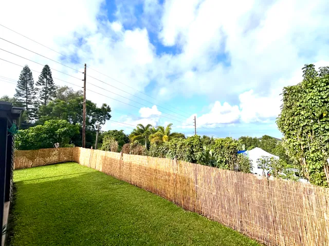 a view of a yard with wooden fence
