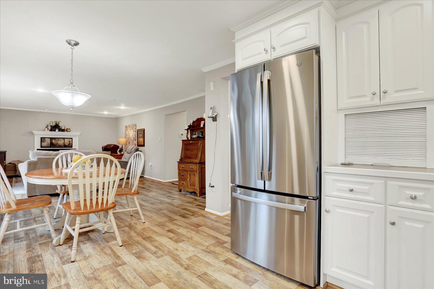 9228 Bowline Road Baltimore, MD 21236 - Photo 13 of 48 a kitchen with stainless steel appliances granite countertop a refrigerator a stove a dining table and chairs with wooden floor