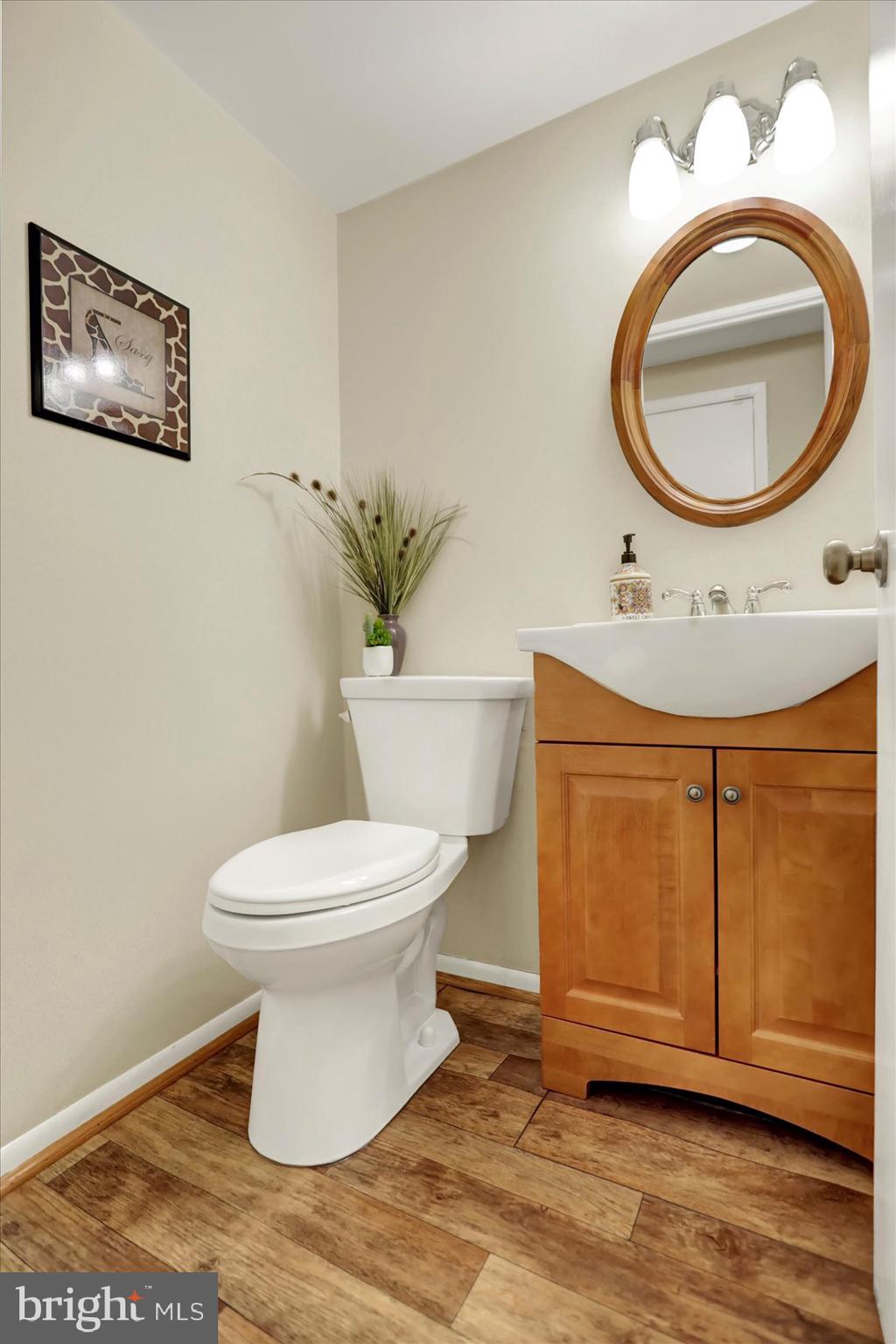 9228 Bowline Road Baltimore, MD 21236 - Photo 21 of 48 a bathroom with a toilet a mirror and vanity