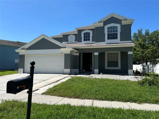 a front view of a house with a yard and garage