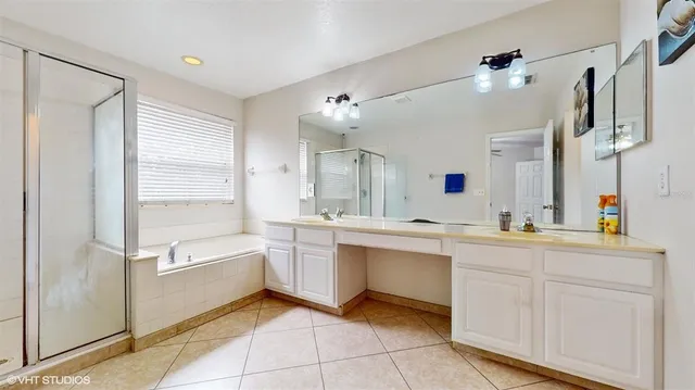 a large white kitchen with a sink and dishwasher a refrigerator with white cabinets