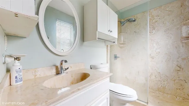 a bathroom with a sink a toilet and a mirror