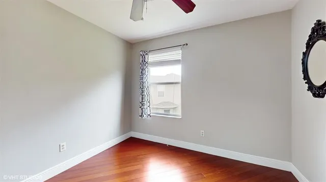 an empty room with a window and wooden floor