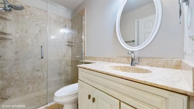 a bathroom with a granite countertop toilet a sink and a mirror