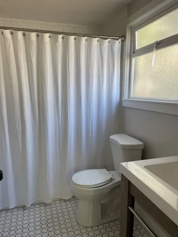 a white toilet sitting next to a shower