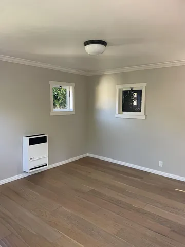 a view of a room with wooden floor and window