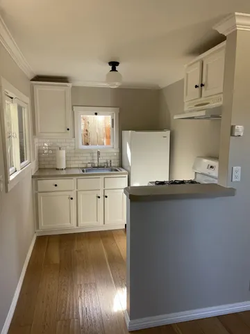 a kitchen with kitchen island granite countertop a sink cabinets and stainless steel appliances