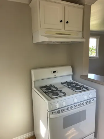 a white stove top oven sitting inside of a kitchen