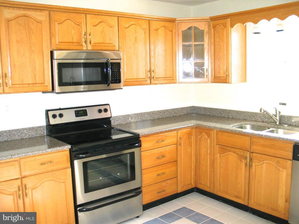 841 Evergreen Road Severn, MD 21144 - Photo 2 of 26 a kitchen with stainless steel appliances granite countertop a stove microwave and cabinets