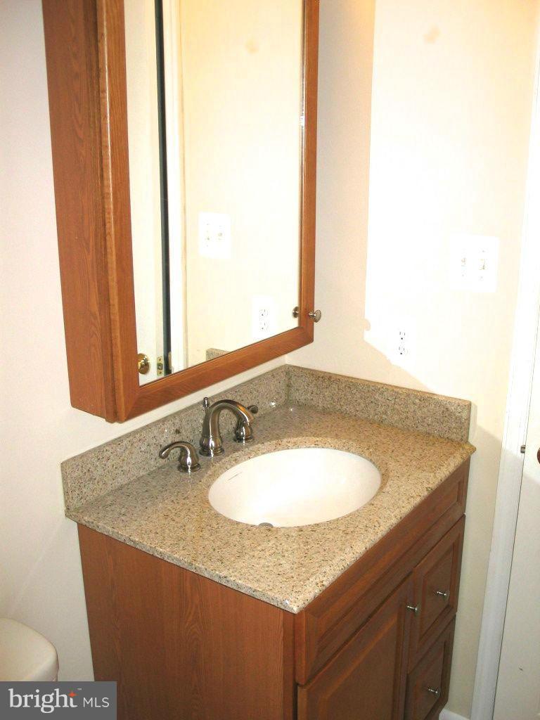 841 Evergreen Road Severn, MD 21144 - Photo 19 of 26 a bathroom with a granite countertop sink and a mirror