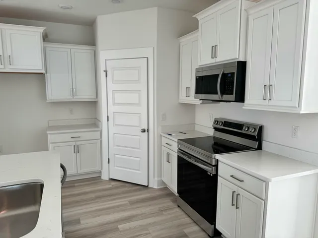 a kitchen with white cabinets and stainless steel appliances