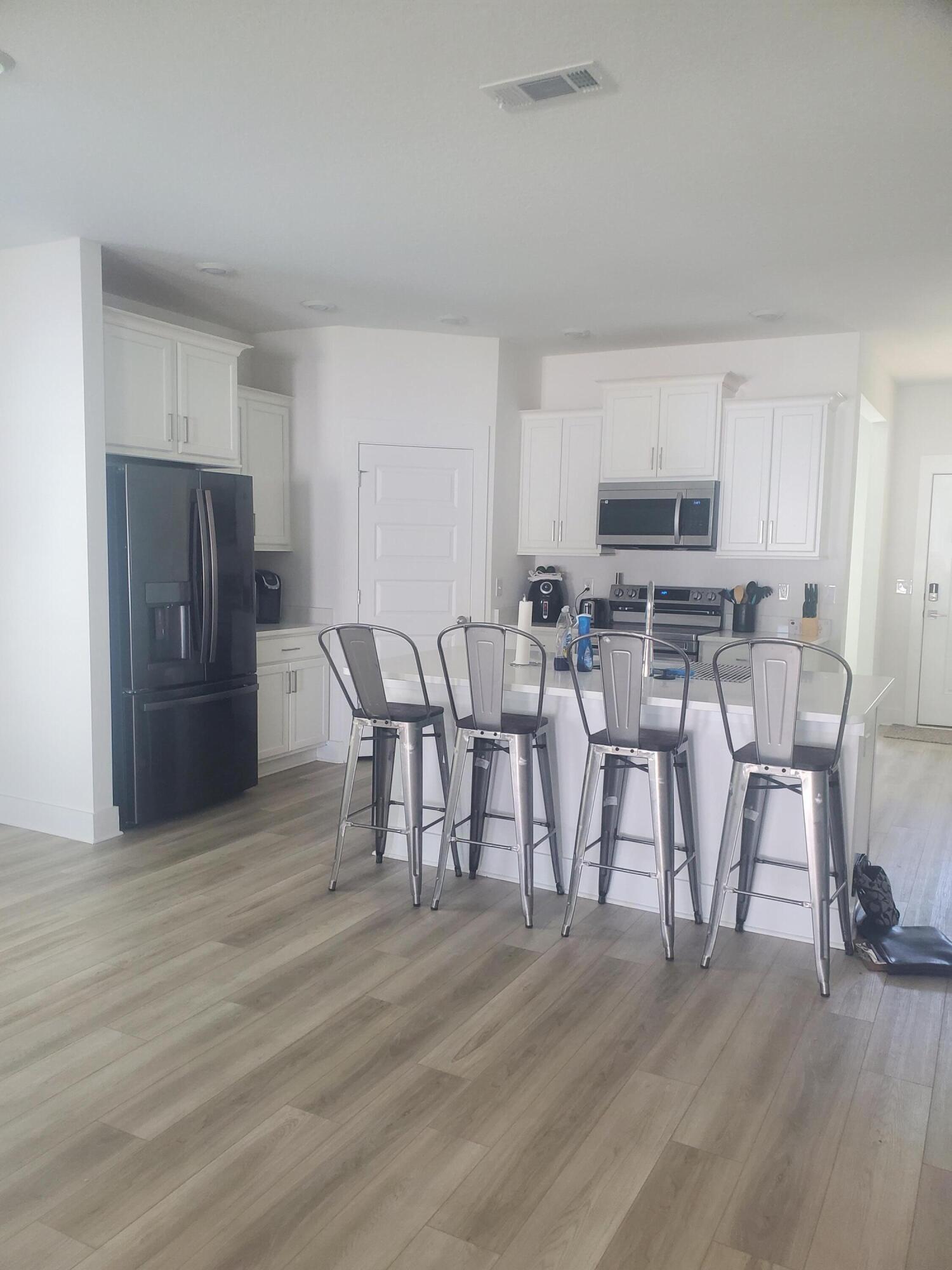 157 Blooming Cove Crestview, FL 32539 - Photo 5 of 14 a kitchen with stainless steel appliances a dining table chairs microwave and sink