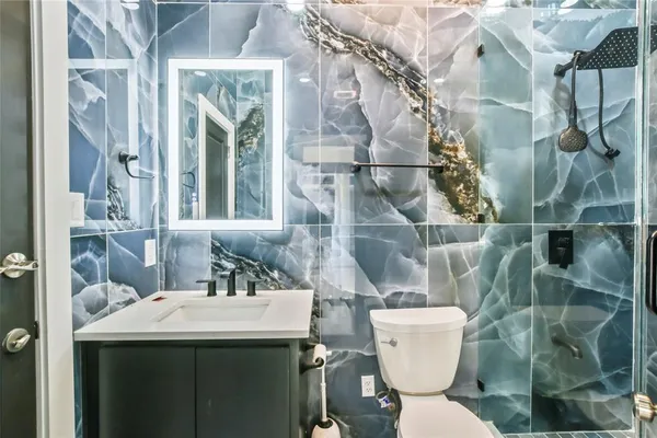 a bathroom with a sink a toilet and shower